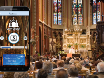 A cell phone is displaying a church in front of a crowd of people.
